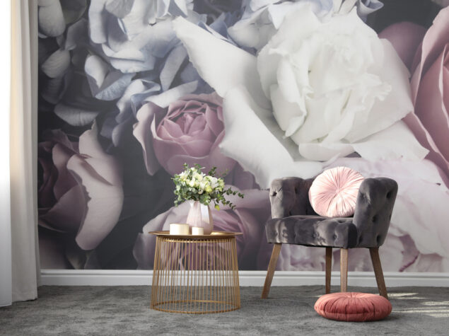 Comfortable armchair near wall with floral print. Stylish room interior